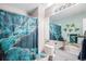 Neat bathroom featuring blue shower curtain and matching toilet seat, sink with modern fixture, and wall decorations at 3647 S Uravan St, Aurora, CO 80013