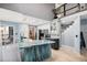 Open kitchen featuring a large island, modern appliances, white cabinets and view of the stairway at 3647 S Uravan St, Aurora, CO 80013