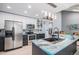Spacious kitchen with stainless steel appliances, island and modern fixtures with backsplash at 3647 S Uravan St, Aurora, CO 80013