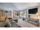 Bright living room with large windows, plush sofa, and modern entertainment setup at 3647 S Uravan St, Aurora, CO 80013