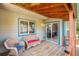 Inviting covered porch featuring a cozy seating area and sliding glass door access to the interior at 3647 S Uravan St, Aurora, CO 80013