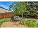 A beautifully landscaped backyard with lush greenery, mulch and mature trees at 6088 Quail Ct, Arvada, CO 80004