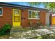 Charming brick home with a bright yellow door, well-maintained lawn, and cozy front patio at 6088 Quail Ct, Arvada, CO 80004