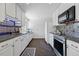 Well-lit kitchen features white cabinetry, mosaic backsplash, and modern stainless steel appliances at 6088 Quail Ct, Arvada, CO 80004