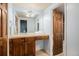 Bright bathroom featuring wood cabinets, a neutral vanity, and a large framed mirror at 7865 E Mississippi Ave # 1102, Denver, CO 80247