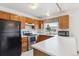 Functional kitchen with white countertops, wood cabinets, and stainless steel appliances at 10241 Routt St, Broomfield, CO 80021