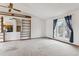 Bright living room with a large window, bookshelves, and neutral carpet at 10241 Routt St, Broomfield, CO 80021