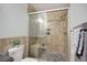 Tiled bathroom featuring glass shower doors, a pebble floor and built-in shower bench at 14590 E 2Nd Ave # B309, Aurora, CO 80011