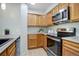 Kitchen showcasing stainless steel appliances, wooden cabinetry, and modern fixtures at 14590 E 2Nd Ave # B309, Aurora, CO 80011