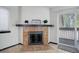 Living room features tiled fireplace with decor, large window, and sliding glass doors to the balcony at 14590 E 2Nd Ave # B309, Aurora, CO 80011