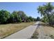 Paved path winds through a green space with mature trees and multiple residential buildings nearby at 14590 E 2Nd Ave # B309, Aurora, CO 80011