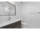 Modern bathroom with dark cabinets, white countertop, and a framed mirror at 1308 Snowberry Ln # 303, Louisville, CO 80027