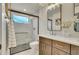 Bathroom featuring double sinks, large mirror, tiled shower with glass door at 1308 Snowberry Ln # 303, Louisville, CO 80027