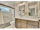 Modern bathroom featuring double sinks, a large mirror, and a tiled shower at 1308 Snowberry Ln # 303, Louisville, CO 80027