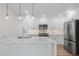Modern white kitchen with stainless steel appliances and quartz countertops at 1308 Snowberry Ln # 303, Louisville, CO 80027