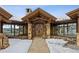 Grand entryway with stone pillars, exposed beams, double doors, and views through picture windows at 300 Little Sallie Barber Trl, Breckenridge, CO 80424