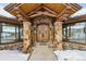 Welcoming stone entryway with exposed wood beams, double doors, and charming rustic decor at 300 Little Sallie Barber Trl, Breckenridge, CO 80424