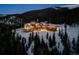 Stunning mountain estate features a log cabin design and beautiful landscaping surrounded by snow-covered trees at 300 Little Sallie Barber Trl, Breckenridge, CO 80424