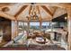Cozy living room with fireplace, vaulted ceilings, log beams, mountain views, and ample seating at 300 Little Sallie Barber Trl, Breckenridge, CO 80424