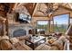 Living room features a stone fireplace, vaulted ceilings, exposed beams, antler chandelier, and mountain views at 300 Little Sallie Barber Trl, Breckenridge, CO 80424