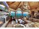 Inviting living room with a stone fireplace, vaulted ceilings, log beams, and breathtaking mountain scenery at 300 Little Sallie Barber Trl, Breckenridge, CO 80424