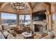 Charming living room features a stone fireplace, mountain views, a mounted TV, and cozy furniture at 300 Little Sallie Barber Trl, Breckenridge, CO 80424