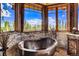 Relaxing bathroom with copper tub and mountain views at 300 Little Sallie Barber Trl, Breckenridge, CO 80424
