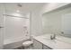 Bright bathroom featuring a tub with white tile surround, a white vanity, and a large mirror at 21964 E 39Th Ave, Aurora, CO 80019