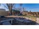 Cozy backyard retreat with a stone fire pit, mature tree, rock border and bench, creating an inviting outdoor space at 437 Raleigh St, Denver, CO 80204