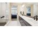 This bathroom features dual sinks, a tiled shower, and is adjoined to the main bedroom at 9162 Star Streak Cir, Littleton, CO 80125