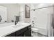 This bathroom features a vanity with dark wood cabinets and a bath/shower combo with white tiling at 9162 Star Streak Cir, Littleton, CO 80125