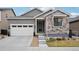 Charming gray home featuring a two-car garage, stone accents, and a well-maintained front yard at 9162 Star Streak Cir, Littleton, CO 80125