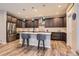 Modern kitchen with dark cabinets, quartz countertops, stainless steel appliances, pendant lights, and stylish bar stool seating at 9162 Star Streak Cir, Littleton, CO 80125