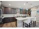 Modern kitchen featuring dark wood cabinetry, quartz countertops, and stainless steel appliances at 9162 Star Streak Cir, Littleton, CO 80125