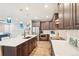 Modern kitchen features a large island with a sink and stunning blue pendant lighting for a bright, fresh aesthetic at 9162 Star Streak Cir, Littleton, CO 80125