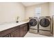 Convenient laundry room featuring front load washer and dryer, white countertop, and dark cabinets at 9162 Star Streak Cir, Littleton, CO 80125