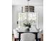 Close-up of a dining table with seating for six, modern lighting, and sliding glass doors to the backyard at 3901 S Dexter St, Cherry Hills Village, CO 80113