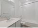Spotless white bathroom featuring shower over tub, sink, toilet and chrome fixtures at 8317 Snake River St, Littleton, CO 80125
