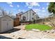 Secluded backyard featuring lush lawn, storage shed, stone patio, and privacy fence at 13199 Ash St, Thornton, CO 80241
