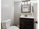 Well-lit half bathroom featuring a dark vanity and white countertops at 13199 Ash St, Thornton, CO 80241