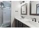 Bright bathroom with dual sinks, granite countertops, and a shower with glass doors at 13199 Ash St, Thornton, CO 80241
