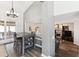 Cozy dining area adjacent to the kitchen, featuring modern table set, stylish chandelier, and view into living room at 13199 Ash St, Thornton, CO 80241