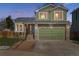 Charming two-story home featuring a stone facade, green siding, well-maintained lawn, and a two-car garage at 13199 Ash St, Thornton, CO 80241