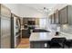 Contemporary kitchen featuring stainless steel appliances, gray cabinetry, countertop seating, and tile backsplash at 13199 Ash St, Thornton, CO 80241