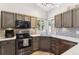 Well-equipped kitchen featuring stainless steel appliances, granite countertops, custom cabinetry, and a view of the backyard at 13199 Ash St, Thornton, CO 80241