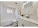 All-white bathroom featuring tile walls, modern fixtures, and a combined tub and shower at 3275 S Decatur St, Denver, CO 80236