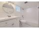 Bright bathroom featuring a modern sink, tile walls, and a combined tub and shower with modern lighting at 3275 S Decatur St, Denver, CO 80236