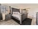 Comfortable main bedroom featuring a gray wood bed frame, side tables, carpet, and a barn door at 11591 S Maiden Hair Way, Parker, CO 80134