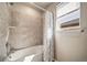 Cozy bathroom with tiled shower and tub combination under a bright window at 17382 Bluetrail Ave, Parker, CO 80134