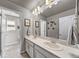 Bright bathroom featuring double sink vanity with white cabinets and decorative wall art at 17382 Bluetrail Ave, Parker, CO 80134